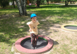 Zdjęcie przedstawia Adama M. z grupy II skaczącego na trampolinie.