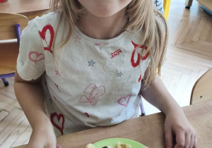 Zdjęcie przedstawia Wandę z grupy IV degustującą przyrządzony przez siebie deserek.