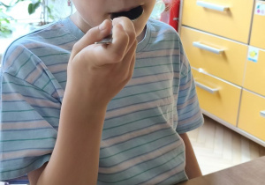 Zdjęcie przedstawia Marcelinę Ł. z grupy IV degustującą przyrządzony przez siebie deserek.
