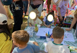 Na tym zdjęciu widać dzieci kolorujące malowanki oraz niektórych rodziców.