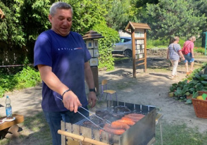 Zdjęcie przedstawia jednego z panów, naszych pracowników obsługującego grilla.