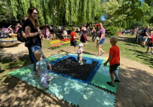 Na tym zdjęciu widać dzieci bawiące się na trampolinie.