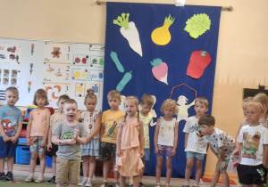 Na tym zdjęciu widać Krysię i Henia P. z grupy I recytujących wierszyk oraz inne dzieci występujące w przedstawieniu stojące z tyłu.
