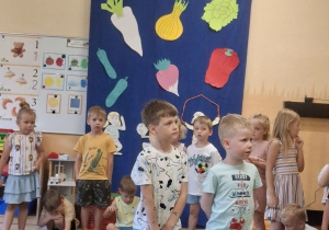 Na tym zdjęciu widać Adama M. i Szymona z grupy II recytujących wierszyk oraz inne dzieci występujące w przedstawieniu stojące z tyłu.