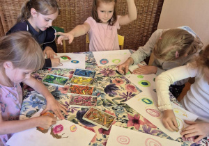 Zdjęcie przedstawia kilka dziewczynek biorących udział w projekcie, wykonujących pracę pod tytułem "Ślimaczki".