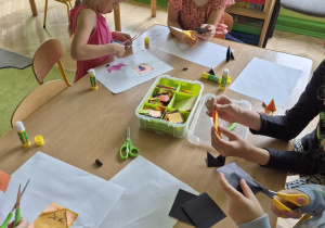 Zdjęcie przedstawia dzieci wykonujące zwierzątka metodą origami.