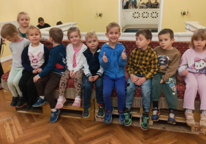 Zdjęcie przedstawia dzieci z grupy III siedzące a holu teatru.