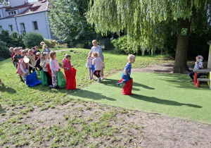 Zdjęcie przedstawia dzieci z grupy IV podczas konkurencji skoki w workach.