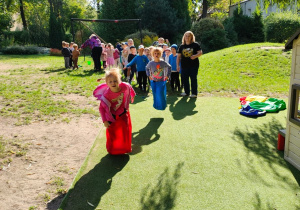 Zdjęcie przedstawia dzieci z grupy III podczas konkurencji skoki w workach.