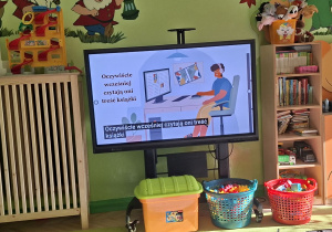 Zdjęcie przedstawia film edukacyjny "Jak powstaje książka?" wyświetlany na monitorze interaktywnym.