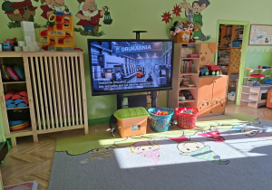 Zdjęcie przedstawia film edukacyjny "Jak powstaje książka?" wyświetlany na monitorze interaktywnym.