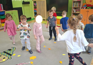 Na tym zdjęciu widać dzieci z grupy I i II podczas zabawy ruchowej połączonej z ćwiczeniami oddechowymi z wykorzystaniem papierowych liści.